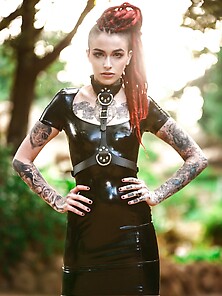 Goth Girl In A Vinyl Dress Poses On Camera Exposing Her Muff For