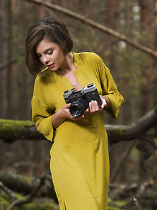 Dress-Wearing Short-Haired Brunette Exploring Nature In The Nude